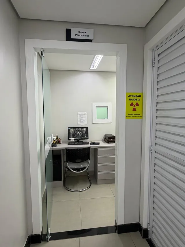 Porta da sala de raio-X panorâmico, com placa de identificação e aviso de radiação